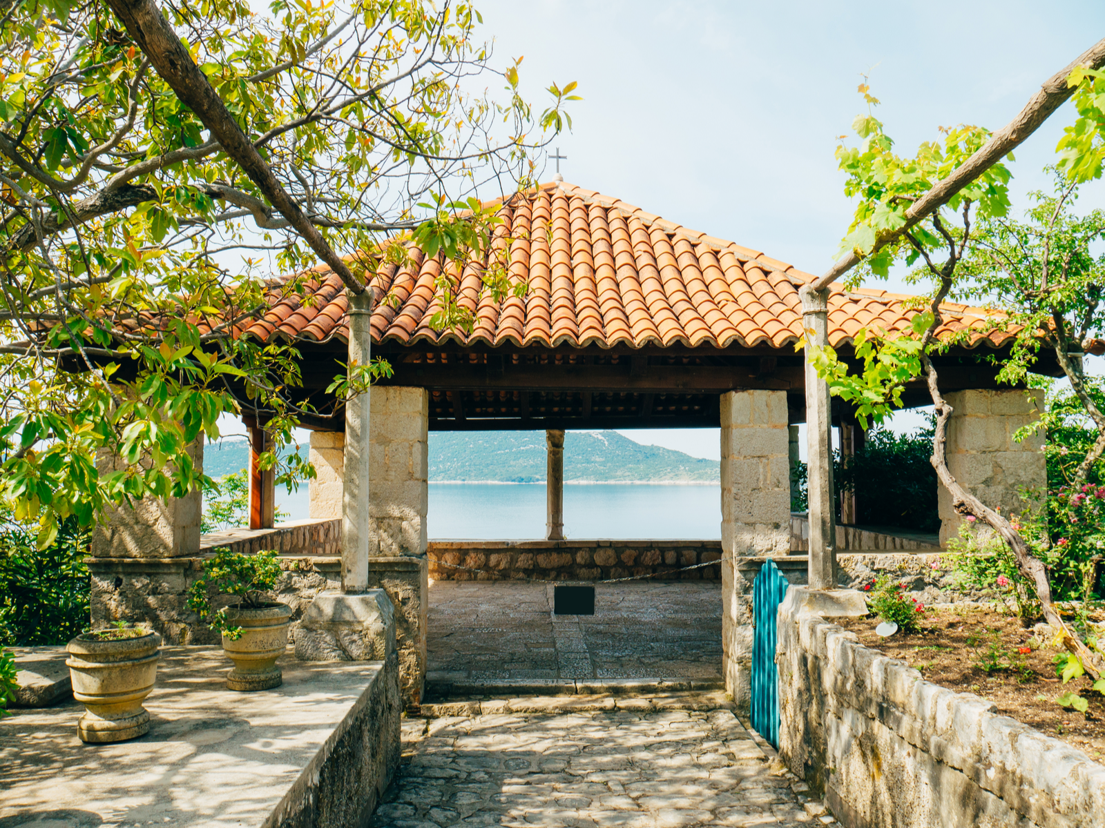 Gazebo with a tiled roof overlooking a calm sea at Trsteno Arboretum in Croatia is one of the Game of Thrones filming locations you can visit in real life