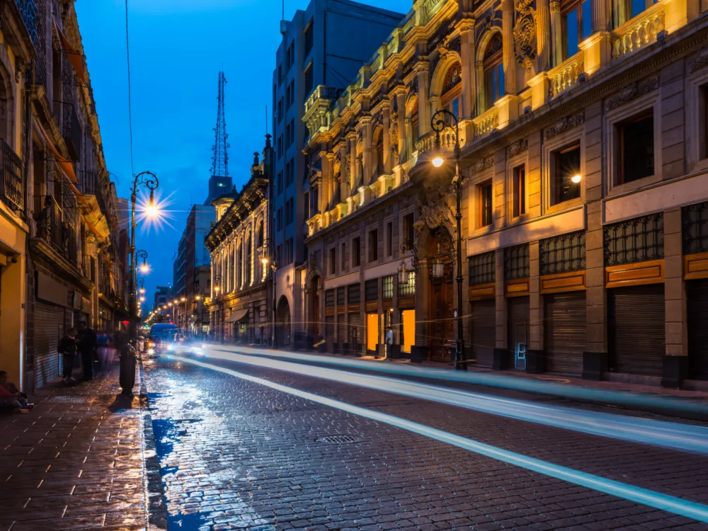 Streets lit up at night with buildings also lighted during the best time to visit Mexico City