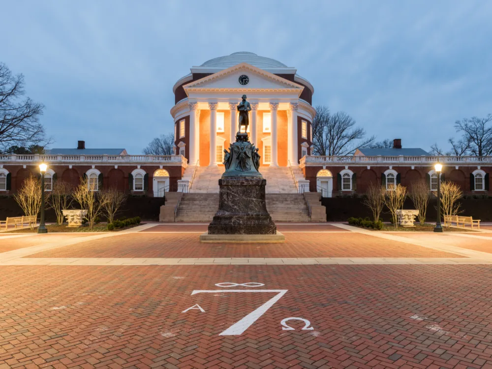 The iconic statue of Thomas Jefferson in front of a classic building with six columns and clock at the top at University of Virginia in Virginia, which is considered one of the most beautiful college campuses