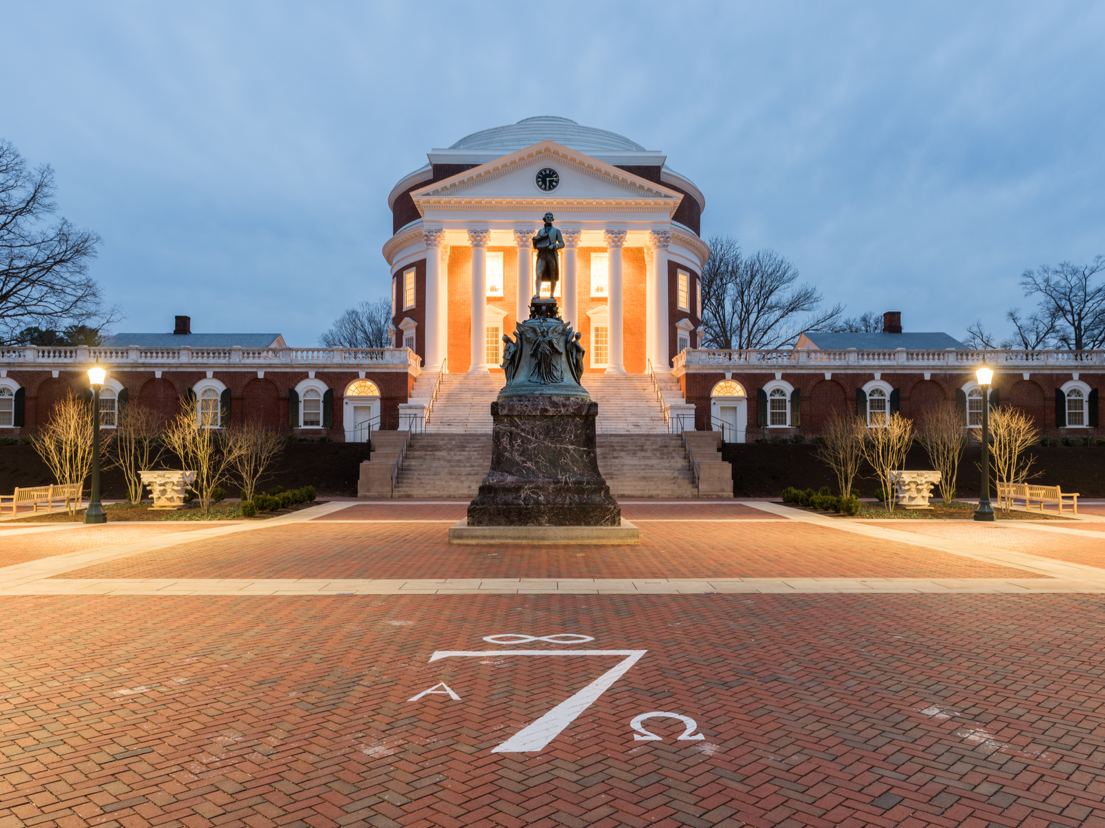 The iconic statue of Thomas Jefferson in front of a classic building with six columns and clock at the top at University of Virginia in Virginia, which is considered one of the most beautiful college campuses