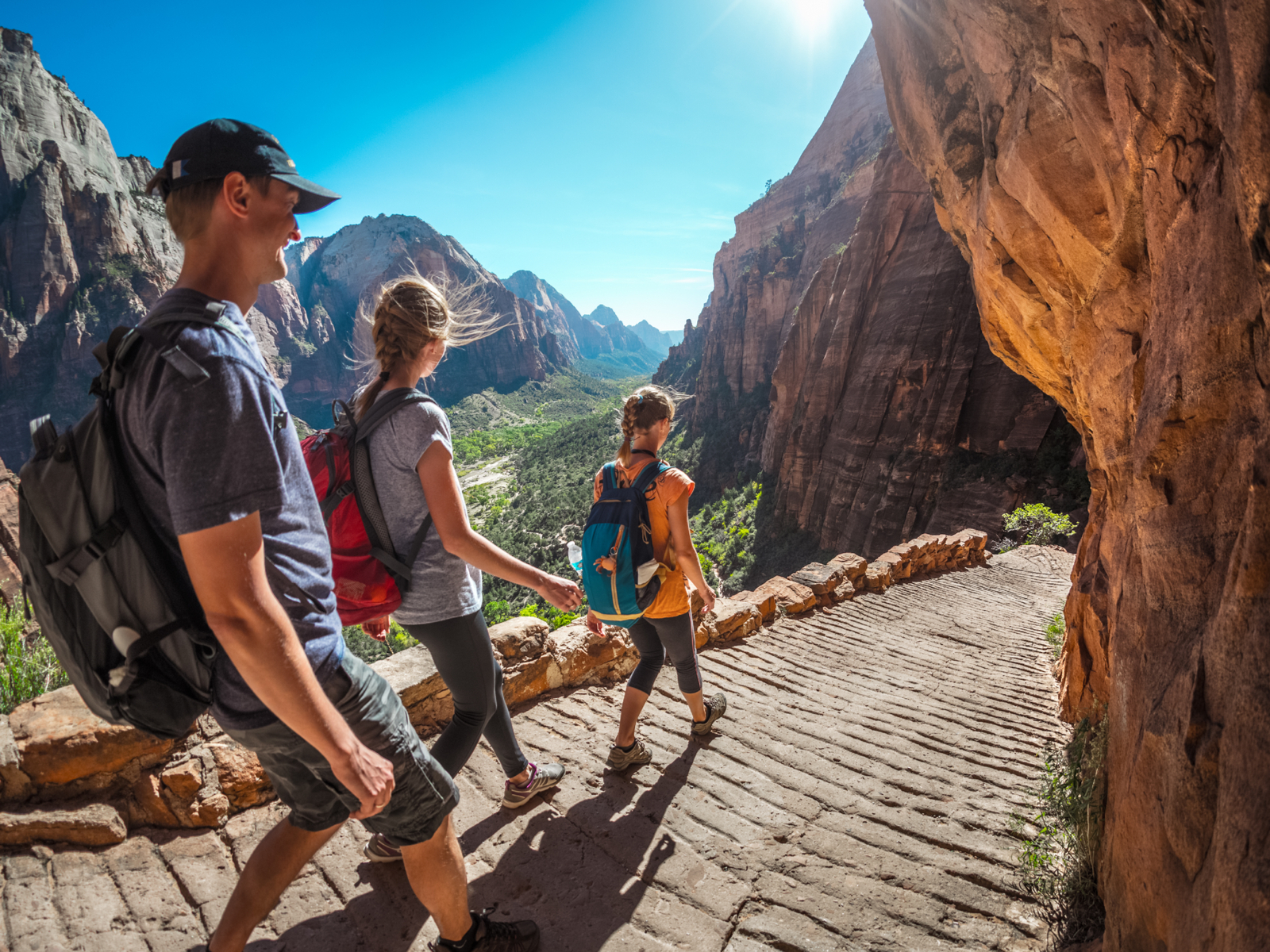 Group of friends hiking down the stairs on a hot and sunny day during the least busy time to visit Zion National Park