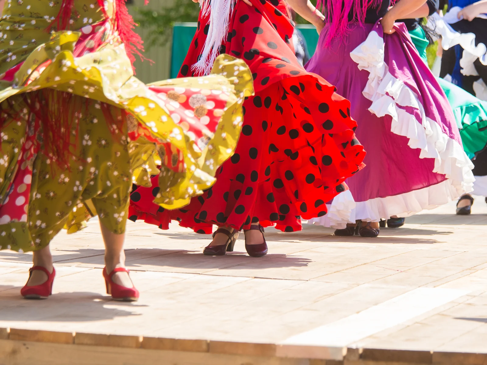 Women dancing in colorful dresses during the best time to go to Spain