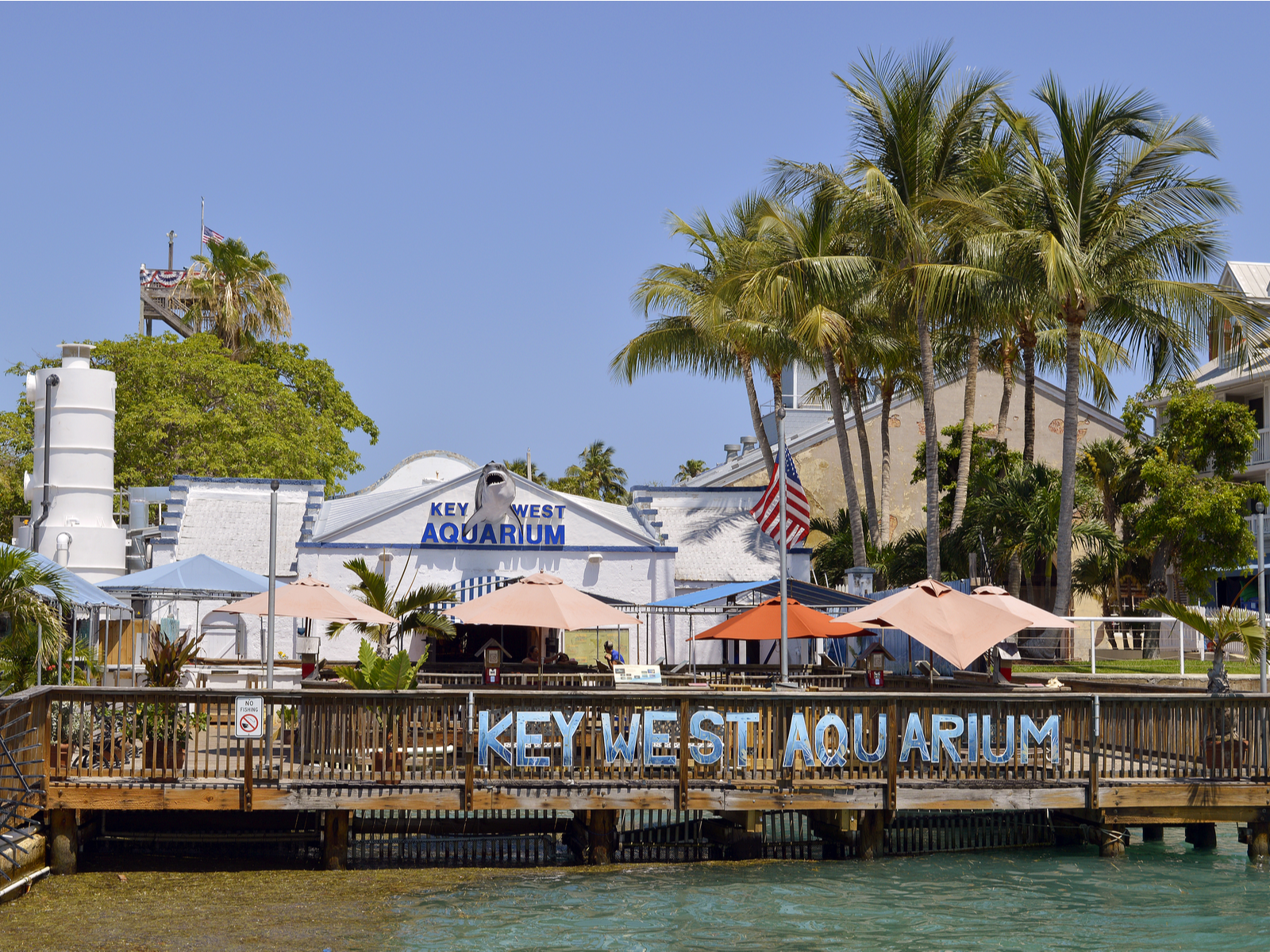 The front of Key West Aquarium with a few cottages and palm trees, one of the best things to do in Key West