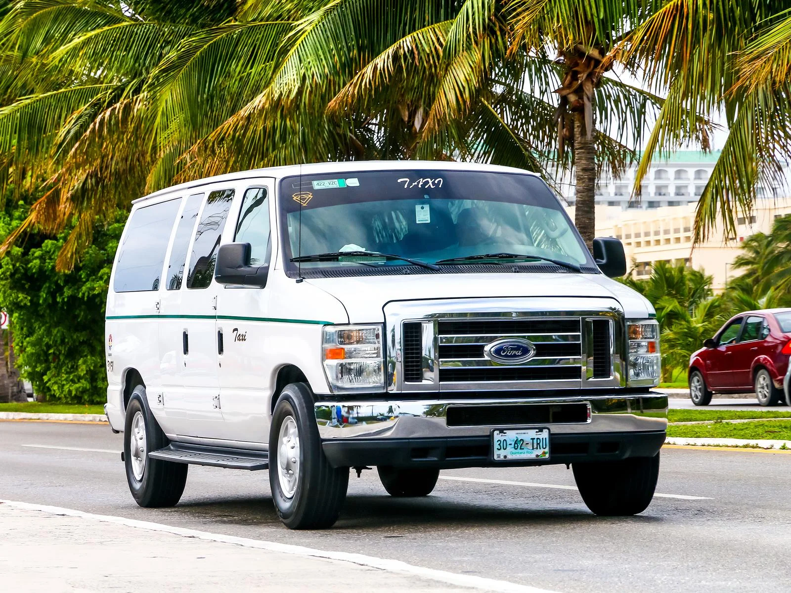 Image of a taxi van in Cabo in front of palm trees