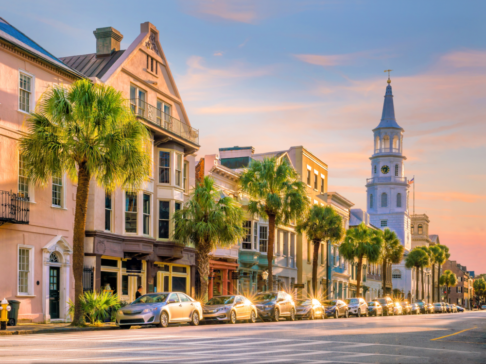 Bright sunset over parked cars and the Historical city of Charleston in South Carolina with palm trees on the sidewalk, one of the most beautiful cities in the US