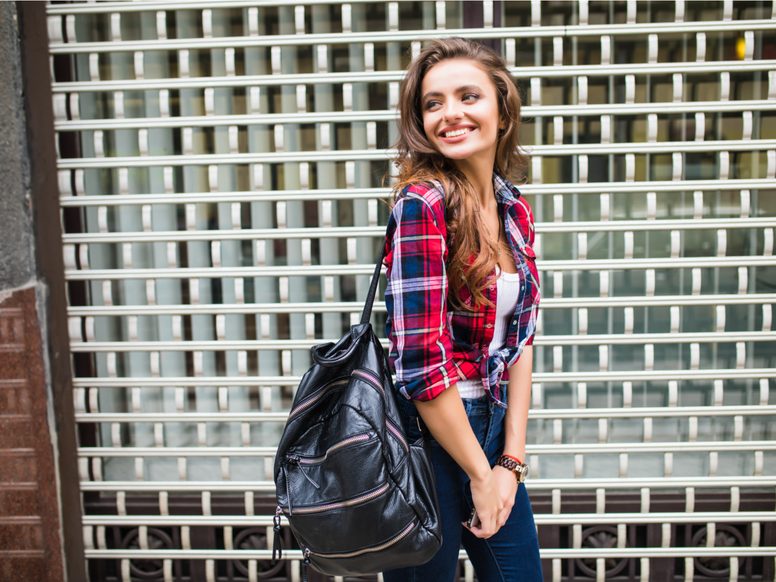 Cute and thin woman smiling and one-strapping one of the best weekender bags