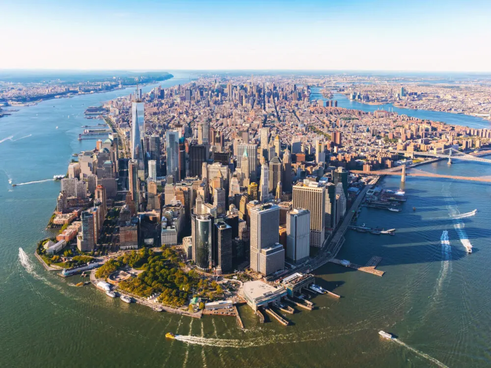 Aerial view of Lower Manhattan, a favorite when considering where to stay in New York City, pictured from the air on a clear day with lots of boats on the water