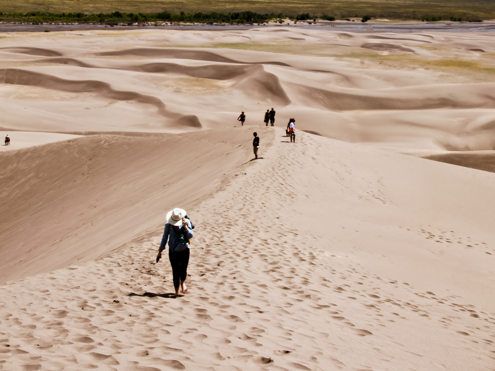 Hikers walking down the Great Sand Dunes for a piece on the most beautiful places in the US