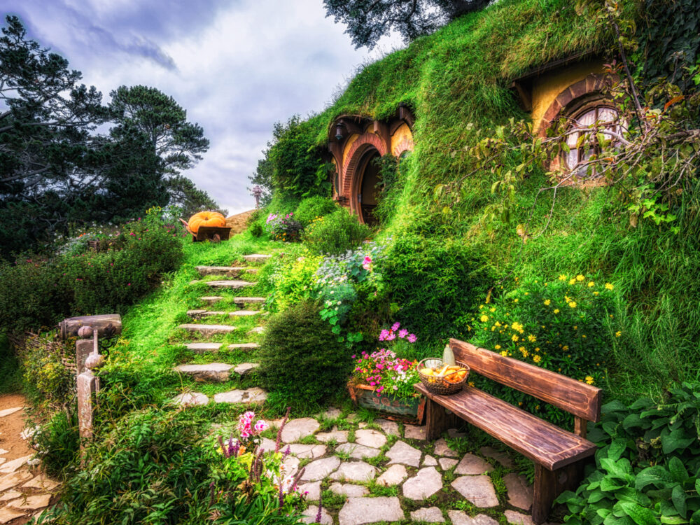 Bilbo Baggins home and hobbit garden pictured during the best time to visit New Zealand with green grass and neat rocks