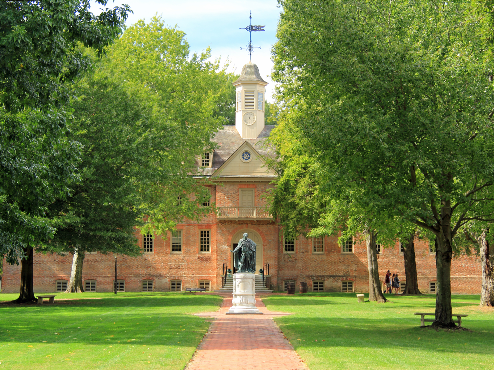 The statue of Lord Botetourt in front of the old building at College of William and Mary in Virginia, known as one of the most beautiful college campuses, with flourishing trees and yard on Spring