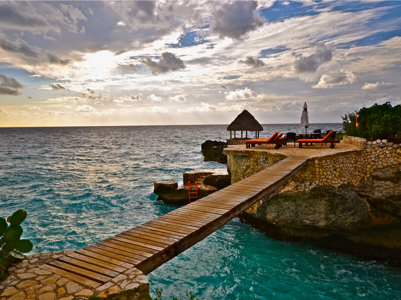 Gorgeous view of a wooden footbridge above the ocean for a piece on the best time to visit Jamaica