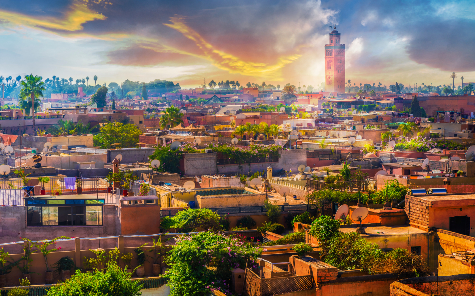 Panoramic view of Marrakech with the mosque tower overlooking the city with a gorgeous sky at dusk during the best time to visit Morocco