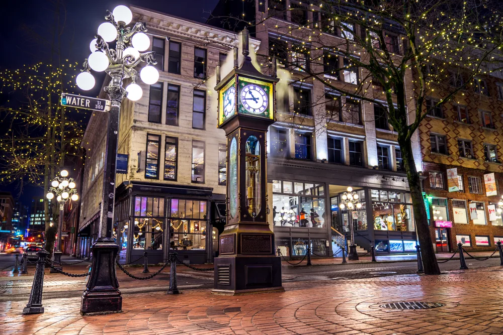 Vancouver pictured during the night with lights in the trees and a clock in the middle of the walking area