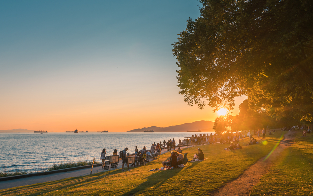 Vancouver beach pictured in the Summer with the sun setting through the trees