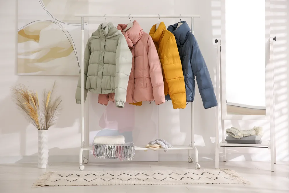 Several of the best woman's heated jackets hanging from a clothes rack