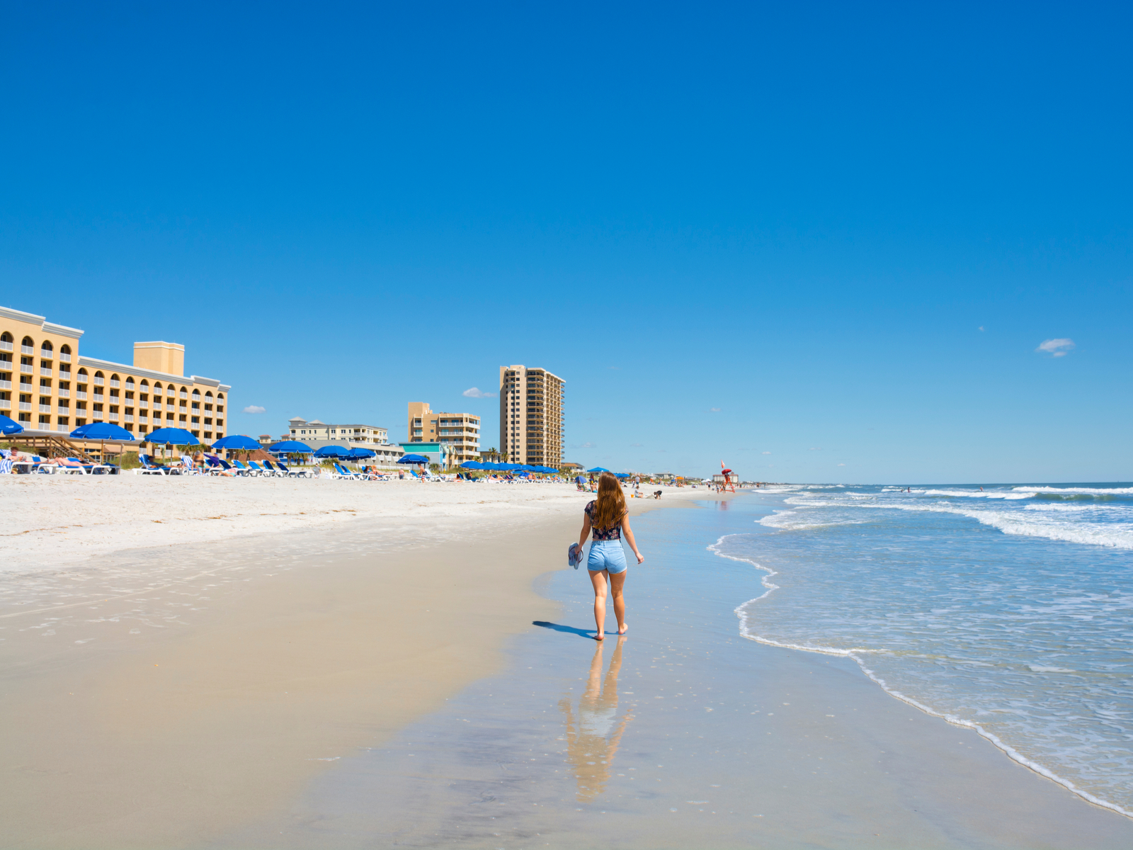 Girl walking on a beach in Jacksonville Florida on a sunny day