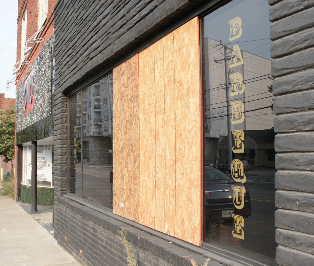 Barber shop with its windows boarded up for a piece on is Nashville Safe