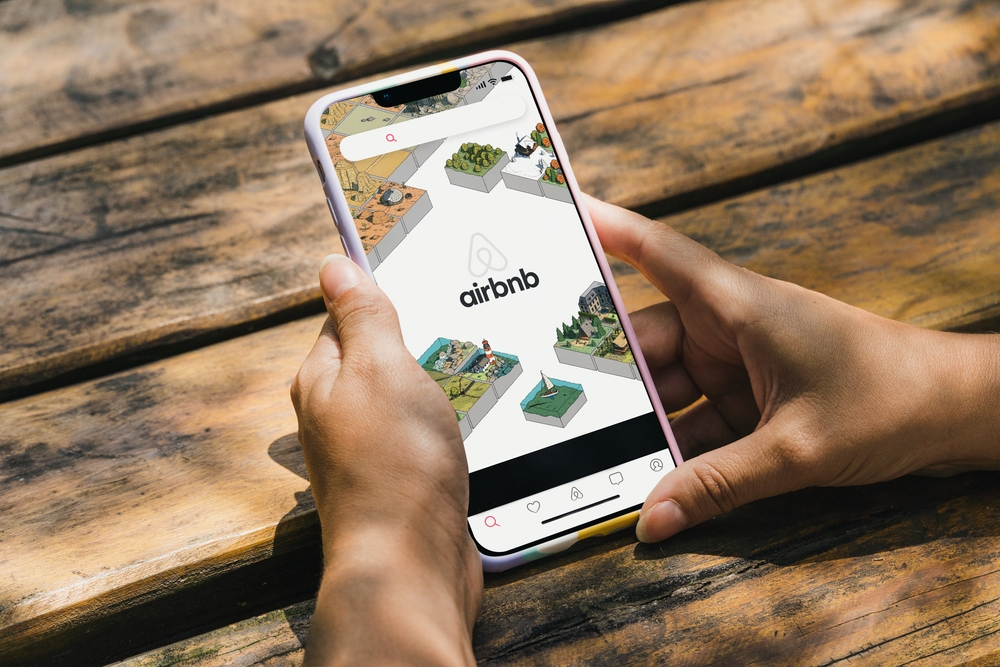 For a piece on the best Airbnbs in Arizona, someone browses the app on a phone while sitting at a picnic bench