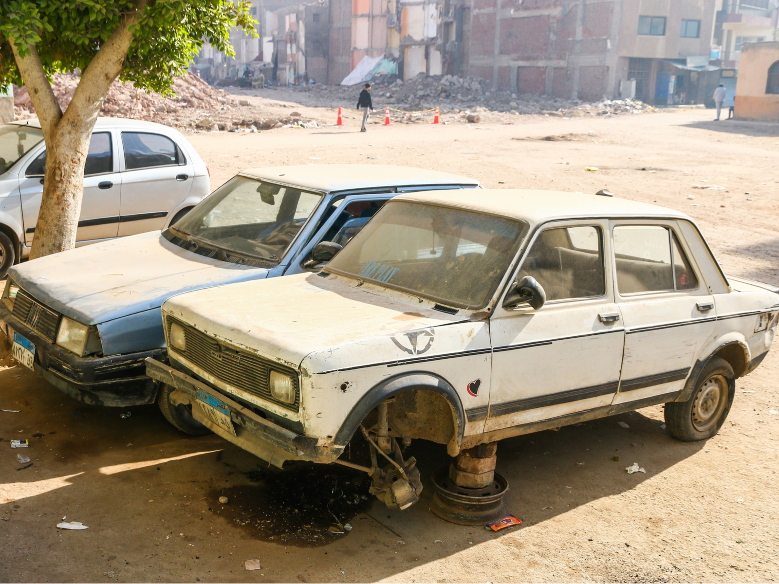 Disassembled car in on blocks in the street for a section on is Egypt safe and how to avoid bad neighborhoods