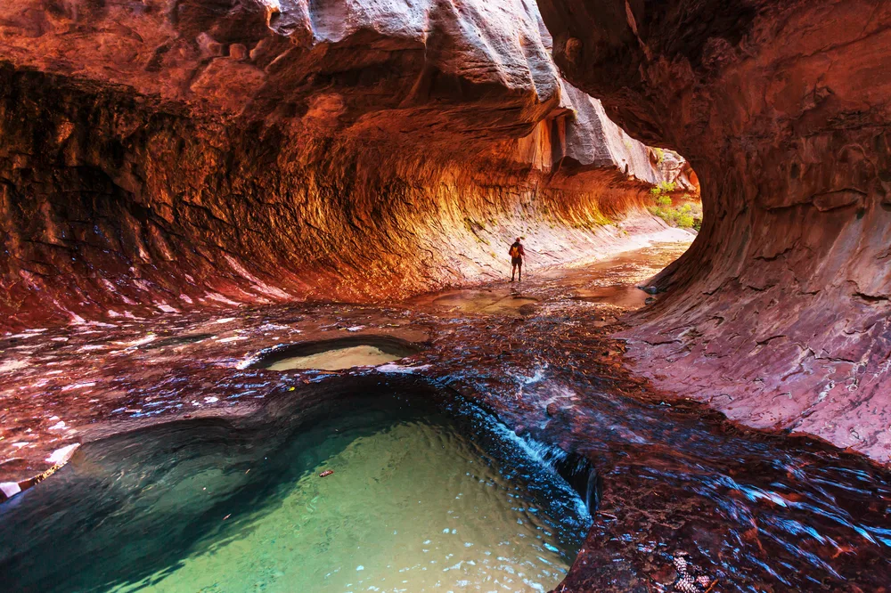 Hiker walking through the Narrows in Zion Park during the best overall time to visit