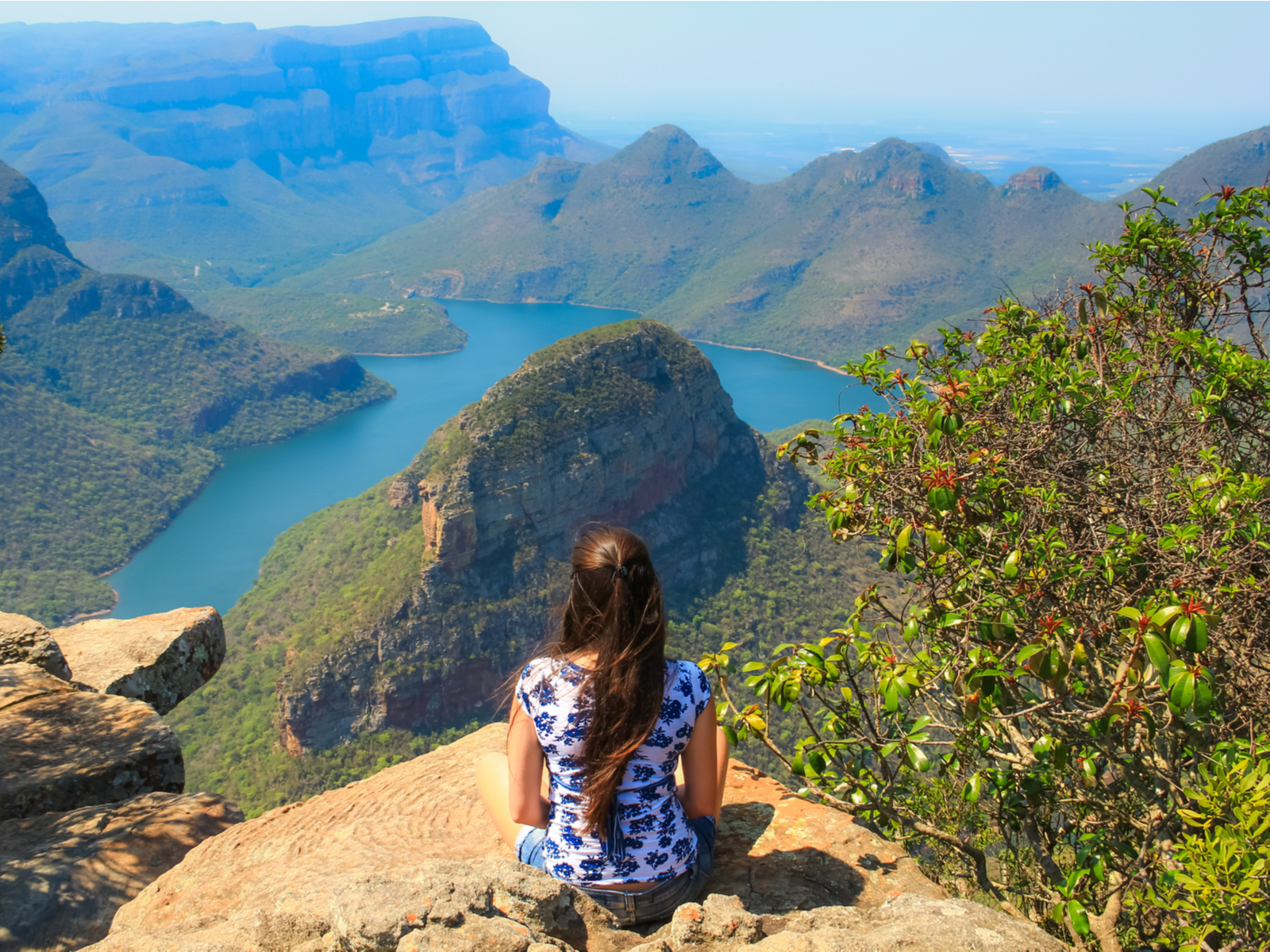 For a piece titled Is South Africa Safe to Visit, a woman sitting on the side of a rock face