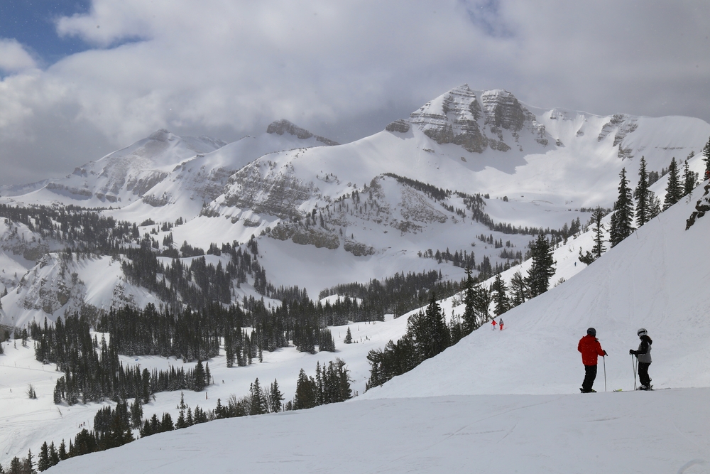 Two people talking on the top of a ski slope for a piece on where to stay in Jackson Hole Wyoming