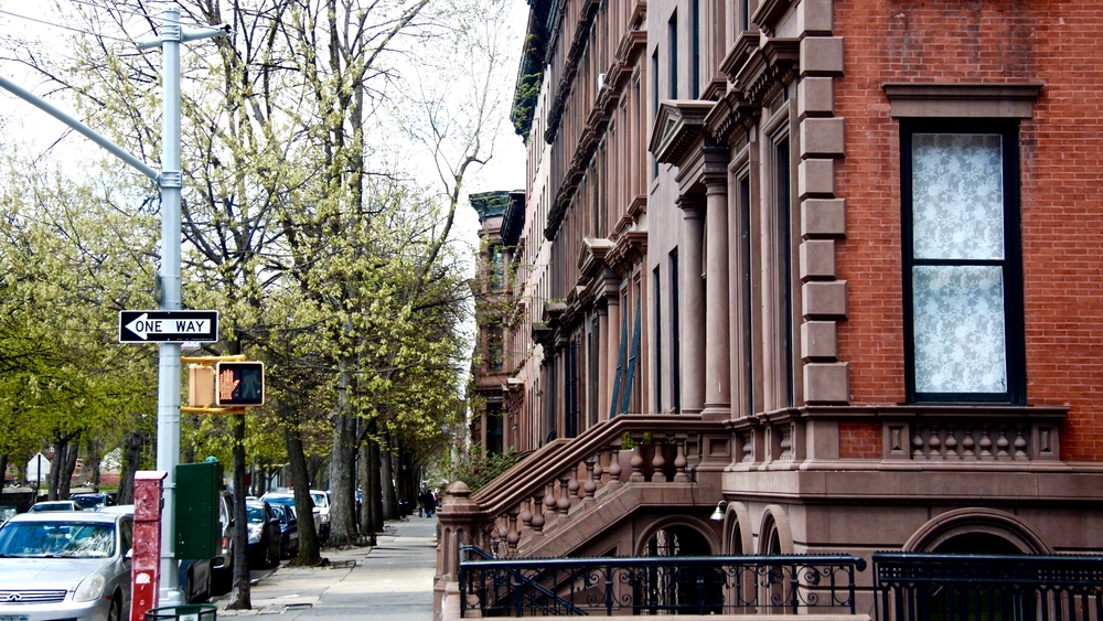 Row of brownstones pictured along a tree-lined street for a piece on Is Brooklyn Safe to Visit
