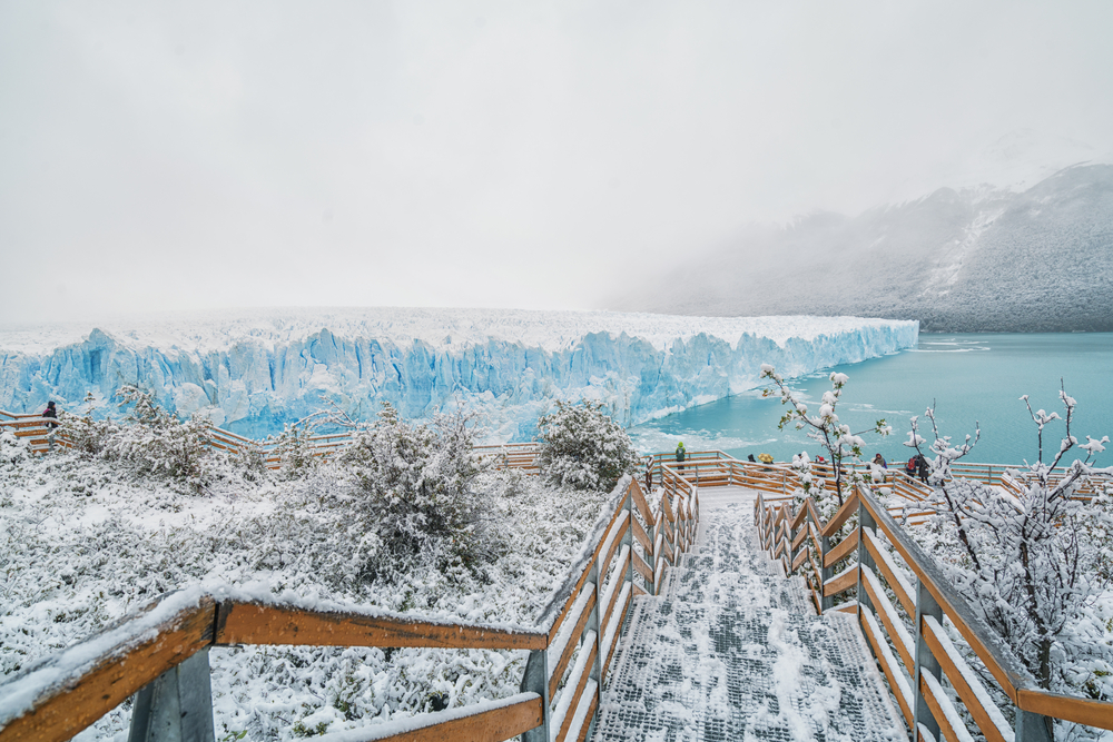 Winter in Patagonia (the worst time to visit) with a snow-covered bridge overlooking the water