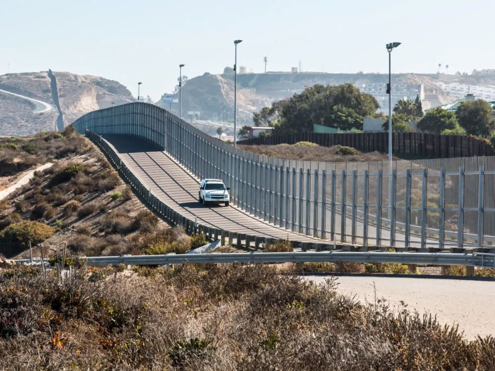 Border patrol vehicle driving along the border of San Diego and Mexico to help answer Is Tijuana Safe