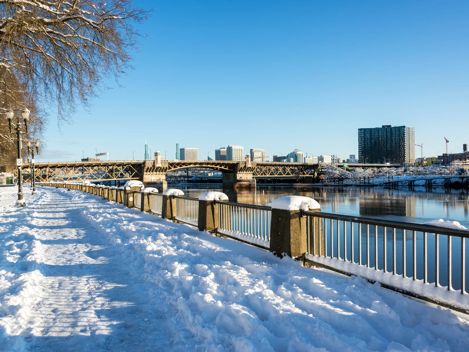 Waterfront view of the river pictured on a snowy but sunny day during the worst time to visit Portland Oregon