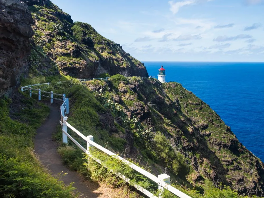A trail at the side of a steep coastal mountain leading towards Makapu’u Point Lighthouse, hiking this trail is one of the best things to do in Oahu
