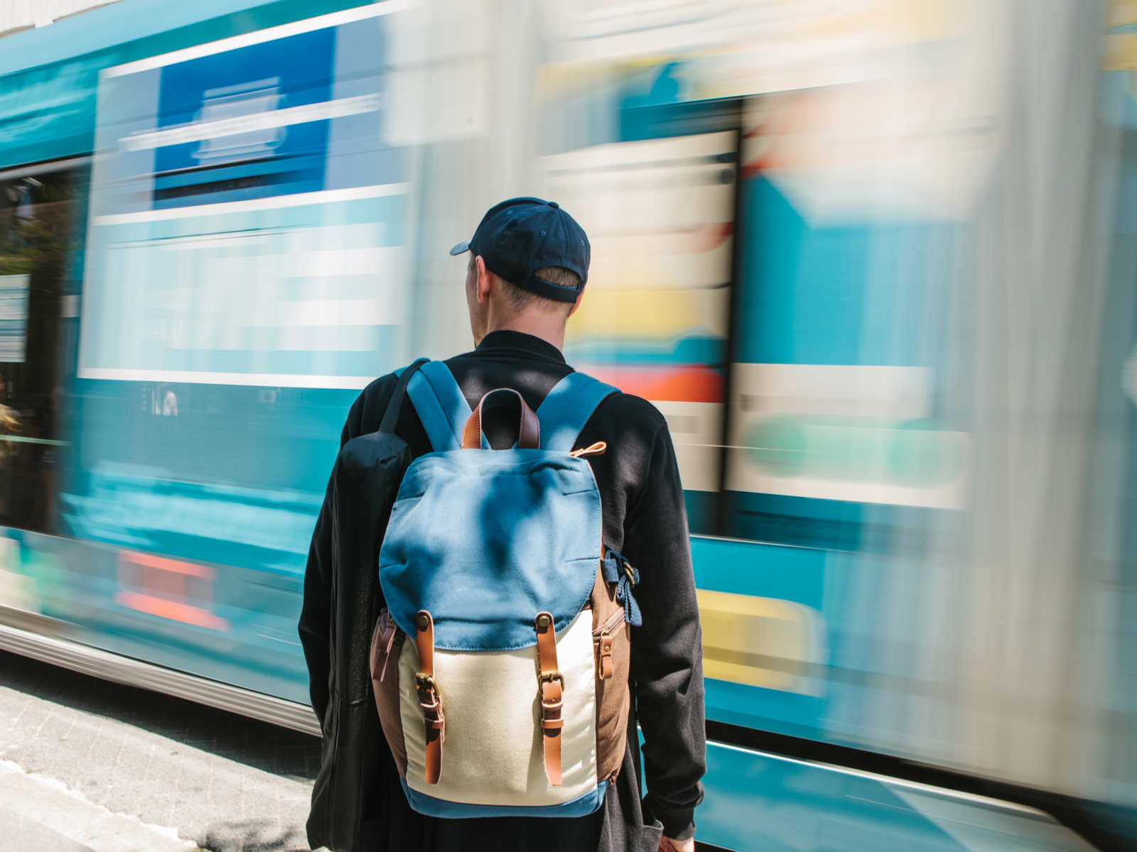 For a piece on the best commuter backpacks, a guy wears a pack while a train speeds by in a blur