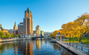 Featured image for a piece titled Is Milwaukee Safe to Visit featuring a skyscraper overlooking the Milwaukee River