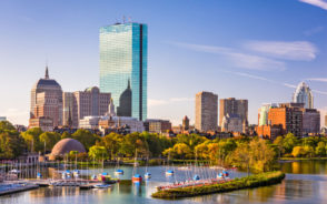 Image of the waterfront and bay and harbor with skyscrapers overlooking it for a piece on the best things to do in Boston