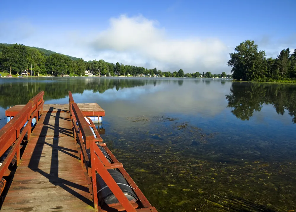 For a section on a guide to where to stay in the Finger Lakes, a red dock juts out into a clear lake