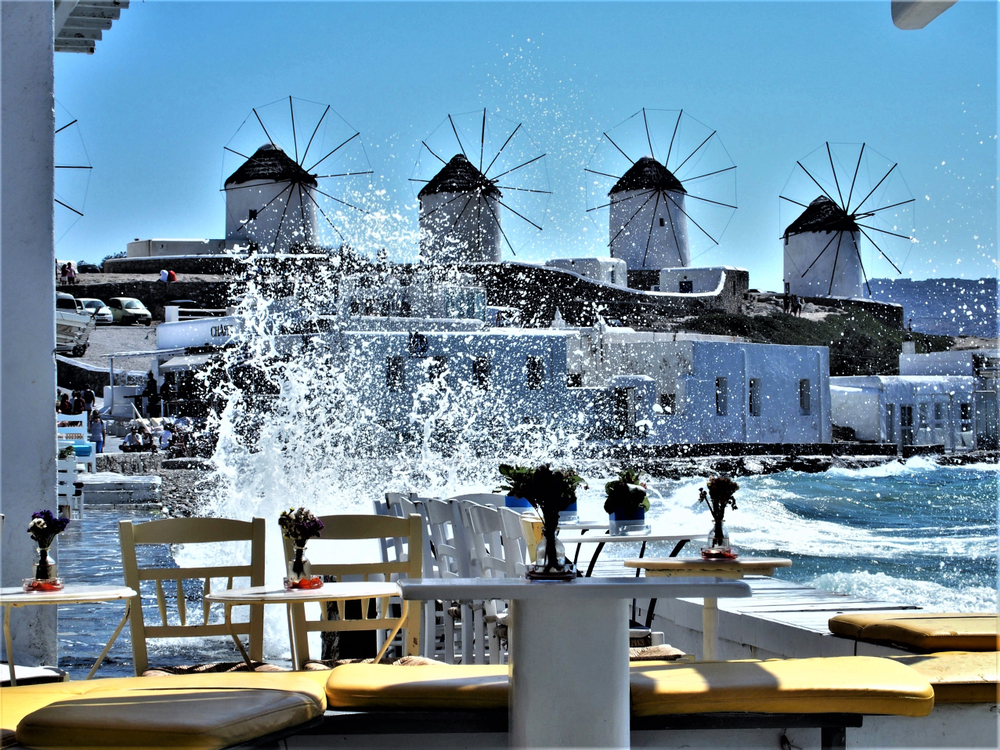 Four flour mills on the south side of the island pictured from a cafe for a piece titled Where to Stay in Mykonos