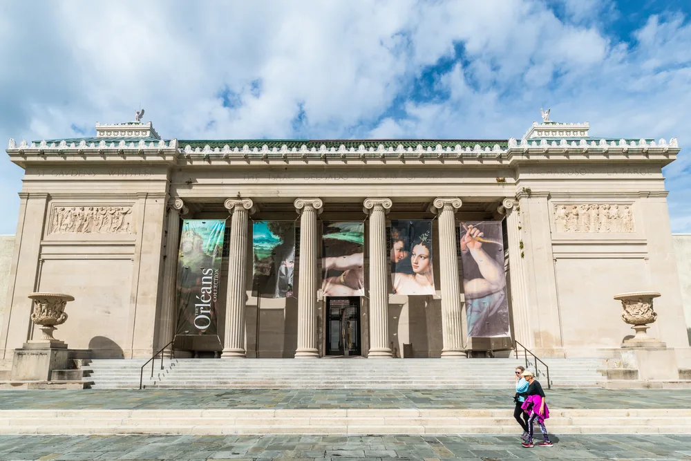 Front of New Orleans Museum of Art with roman style columns and art banners in front, one of the best destinations and things to do in New Orleans.