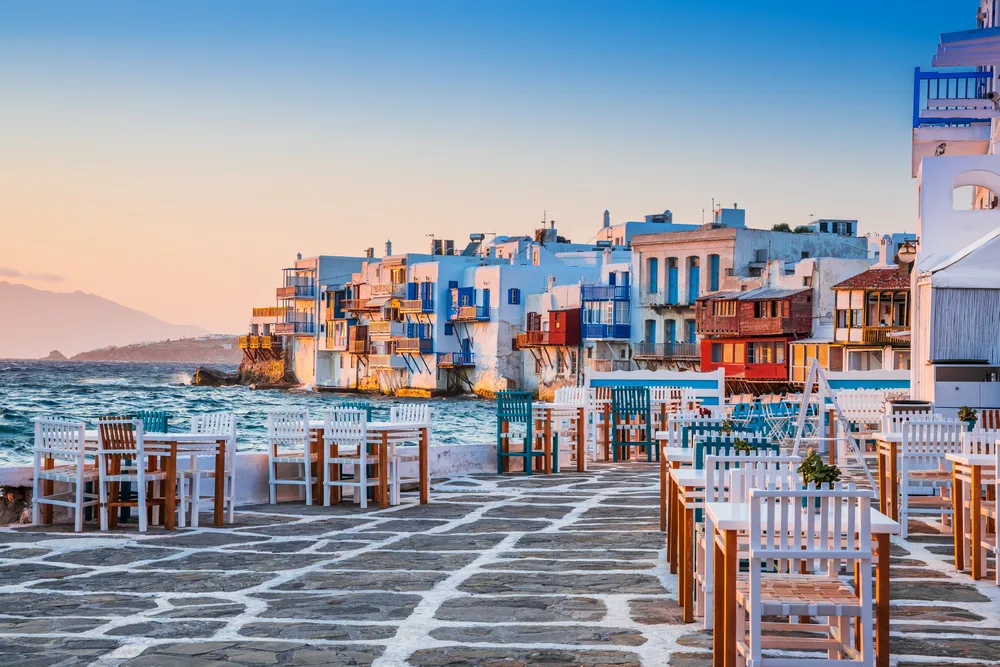 Little Venice pictured at sunset with tables by the ocean for a piece titled Where to Stay in Mykonos