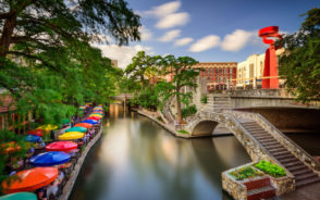 Featured image of the riverwalk and colorful umbrellas at the restaurants along the canal during the best time to visit San Antonio