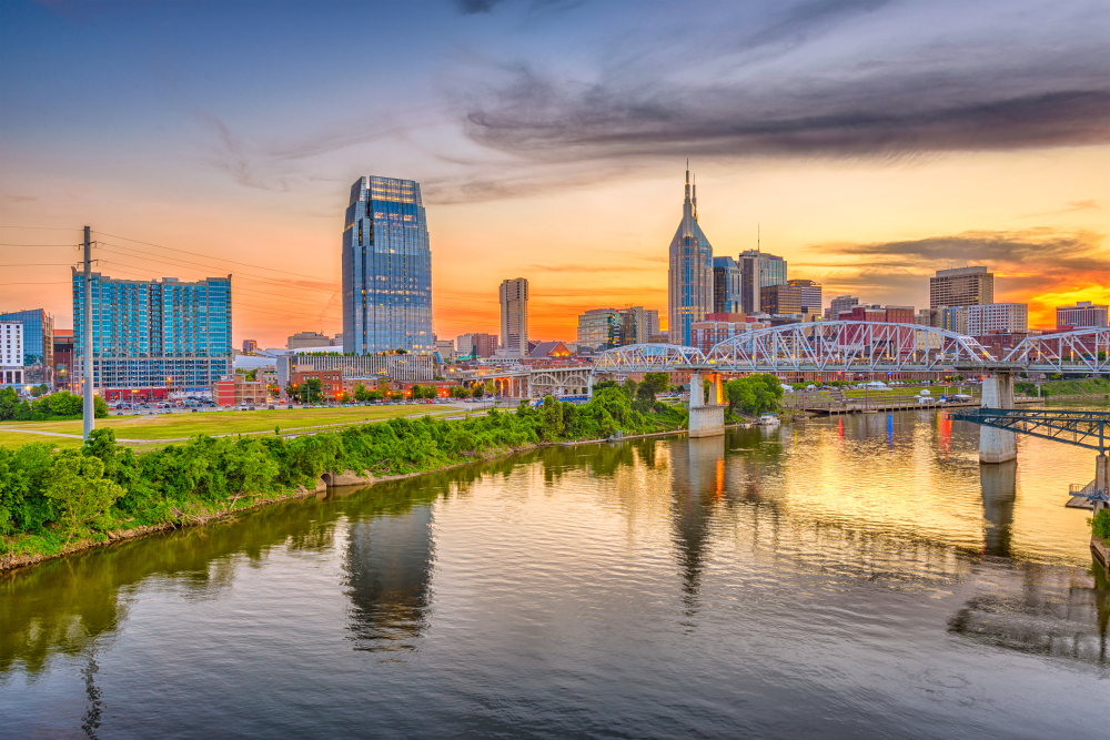 Downtown Nashville skyline showing the pedestrian bridge and river in late summer during the best time to visit Tennessee