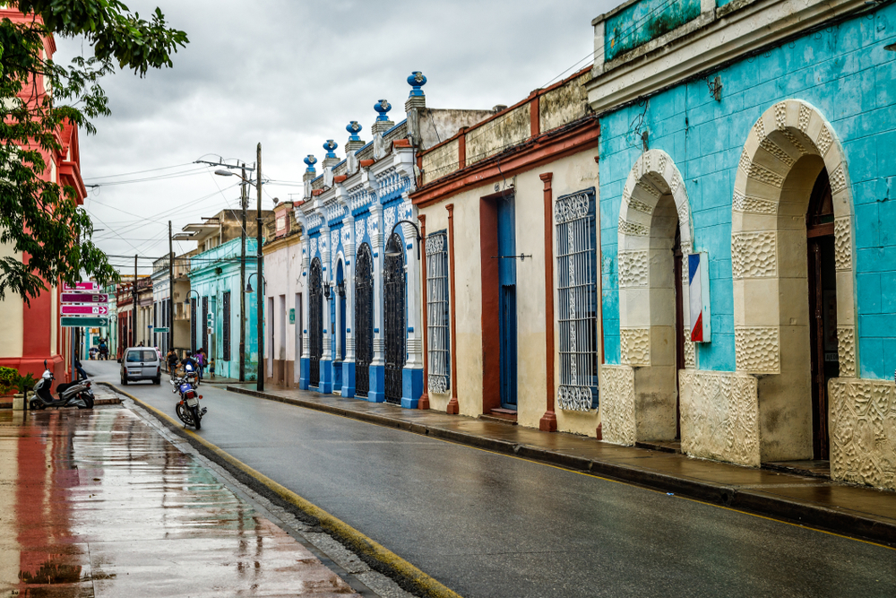 Street view with colorful buildings in Camaguey after a rainstorm showing the worst time to visit Cuba