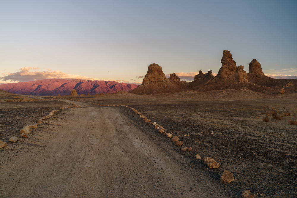 Gorgeous rock formations pictured in the evening on a dirt road for a piece on where to stay in Death Valley