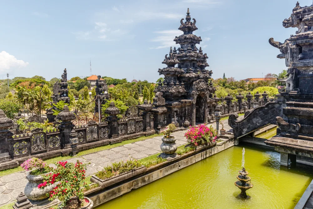 Beautiful historic temple seen overlooking a treed neighborhood in Denpasar, one of our picks for where to stay in Bali
