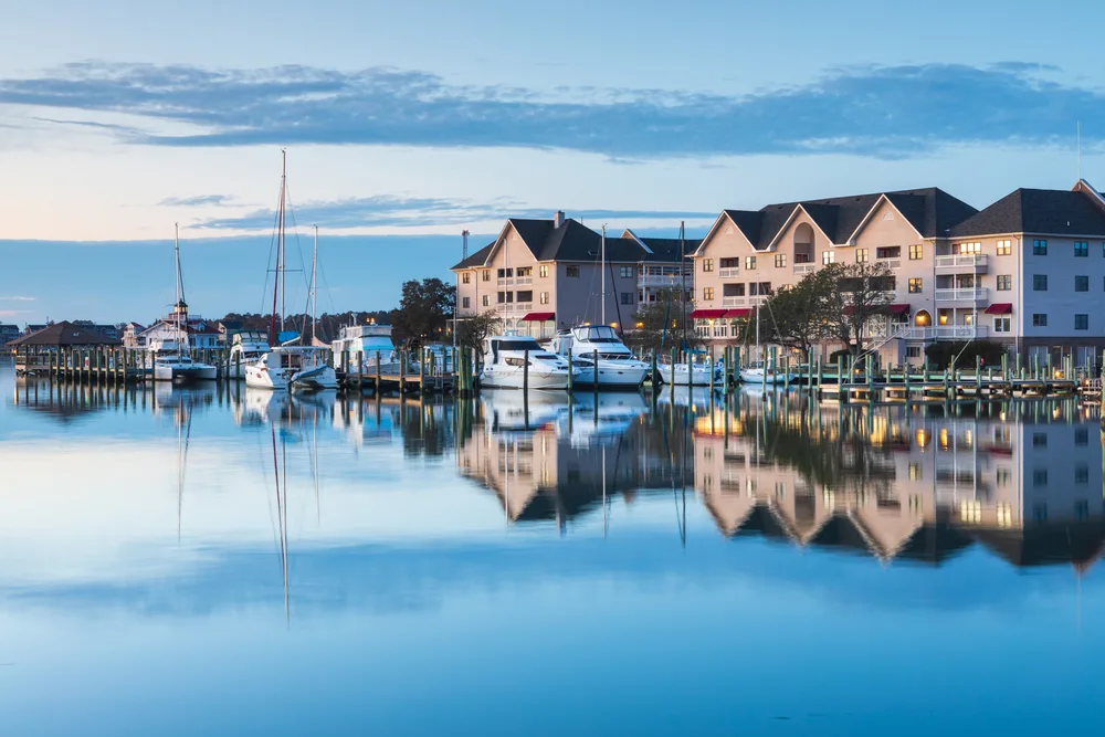 Charming view of the coastal town of Manteo with condos and hotels overlooking sailboats on the glass-flat water