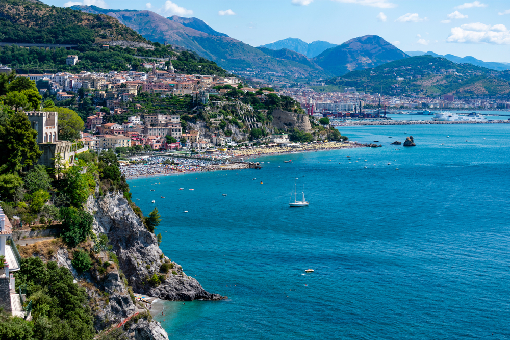 View of Vietri, one of the best places to stay on the Amalfi Coast, pictured from the top of a hill on the rocky coastline with blue water below on a sunny day