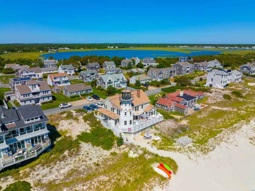Aerial photo taken on a clear summer day depicting one of the best places to stay in Cape Cod, West Yarmouth, with a giant marsh in the background