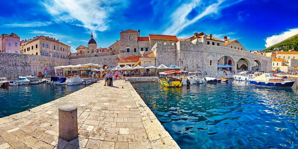 The old town area seen through a fisheye lens from a person standing on a block dock for a piece on where to stay in Dubrovnik