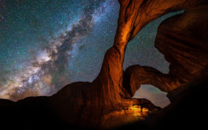 The gorgeous view of the Milky Way pictured at night from below a rock formation during the overall best time to visit Arches National Park