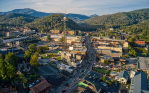 Aerial shot of the downtown area with a tower and hills in the background pictured during the best time to visit Gatlinburg