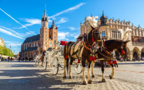 Horses pull a carriage in Krakow in the middle of the spring during the best time to visit Poland